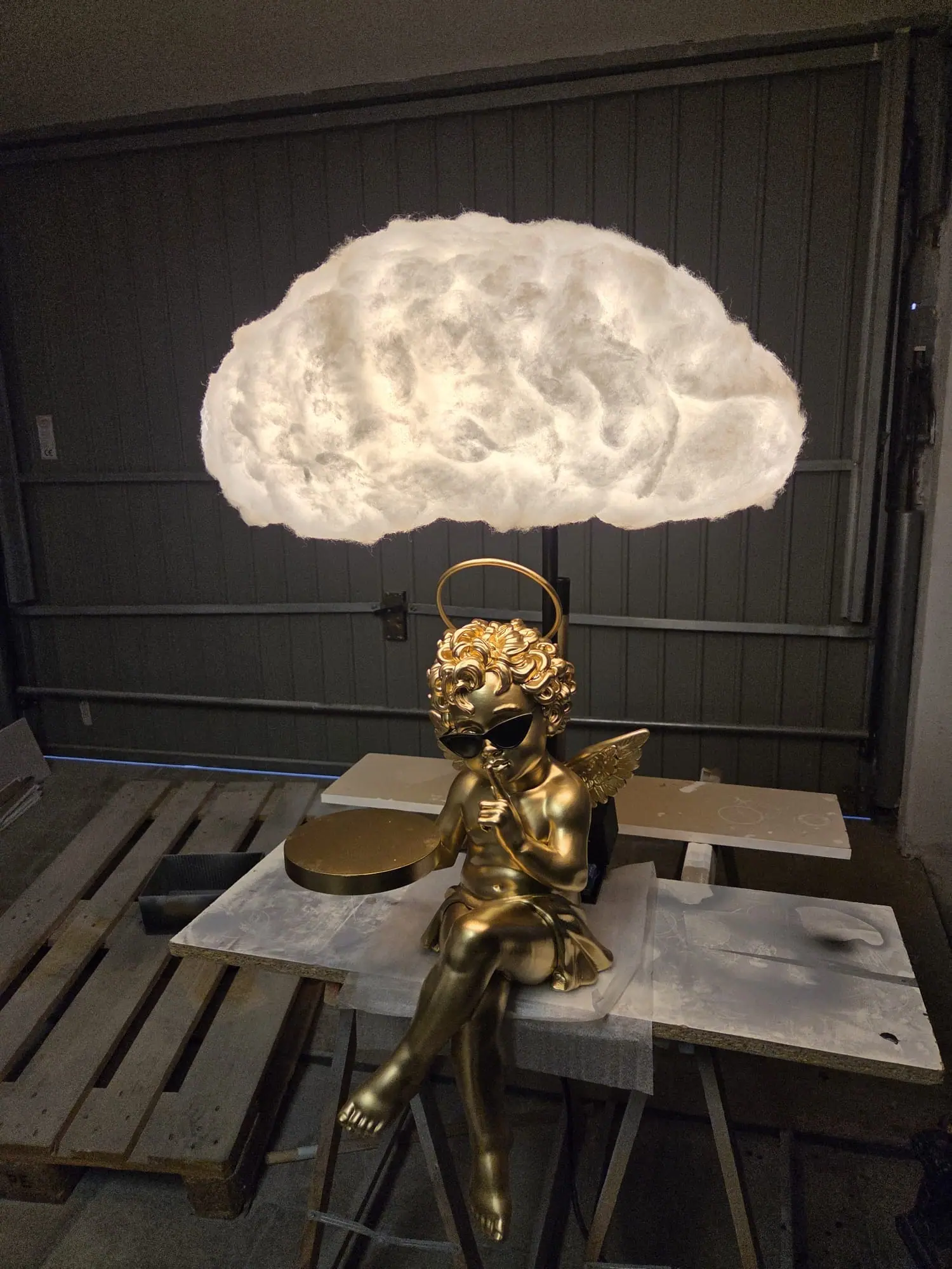 El cupido dorado sentado en el taller con la nube encendida encima