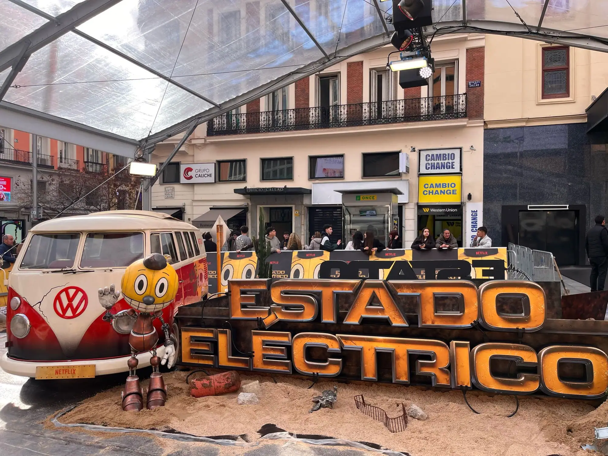 Decorado del estreno de Estado eléctrico con una calle de fachadas antiguas y el título en volumen