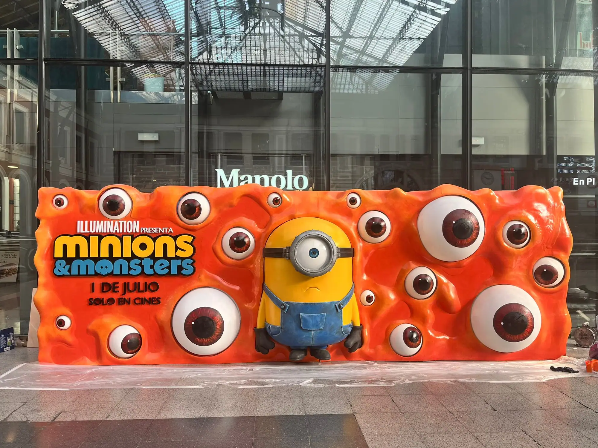 Corpóreo publicitario de gran formato con un personaje y ojos en relieve, montado en un centro comercial