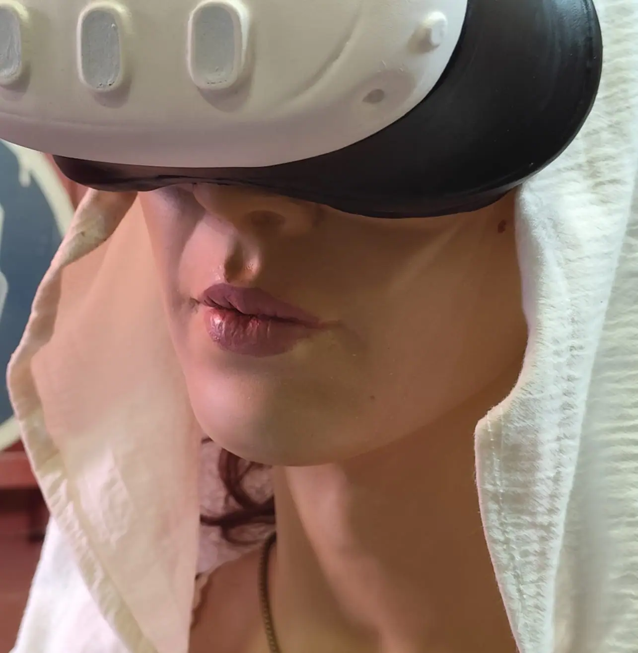 Detalle de la boca y la barbilla de la figura, pintadas a mano, bajo las gafas de realidad virtual