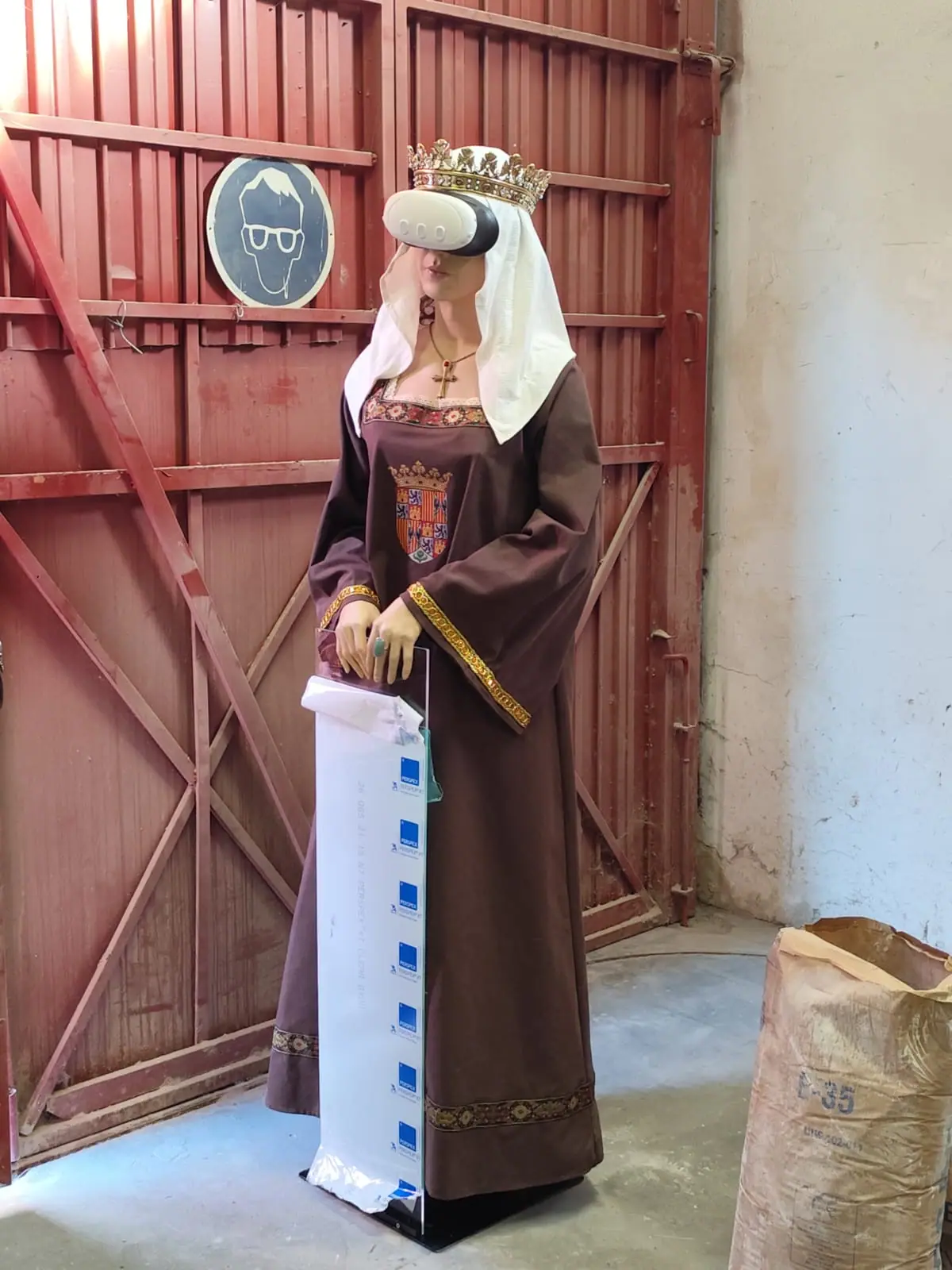 La figura de Isabel la Católica de tres cuartos, sujetando un cartel con las dos manos