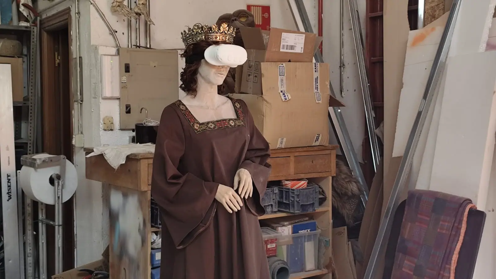 La figura de Isabel la Católica vestida en el taller, entre cajas y herramientas