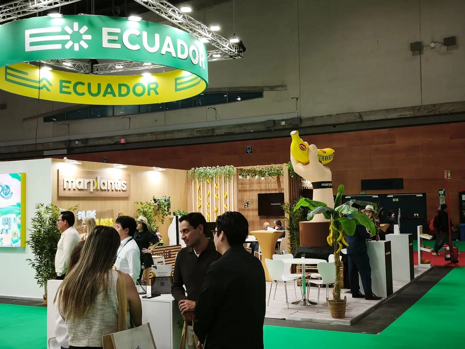 El stand de Marplantis visto desde lejos, con la mano y el plátano asomando entre la gente