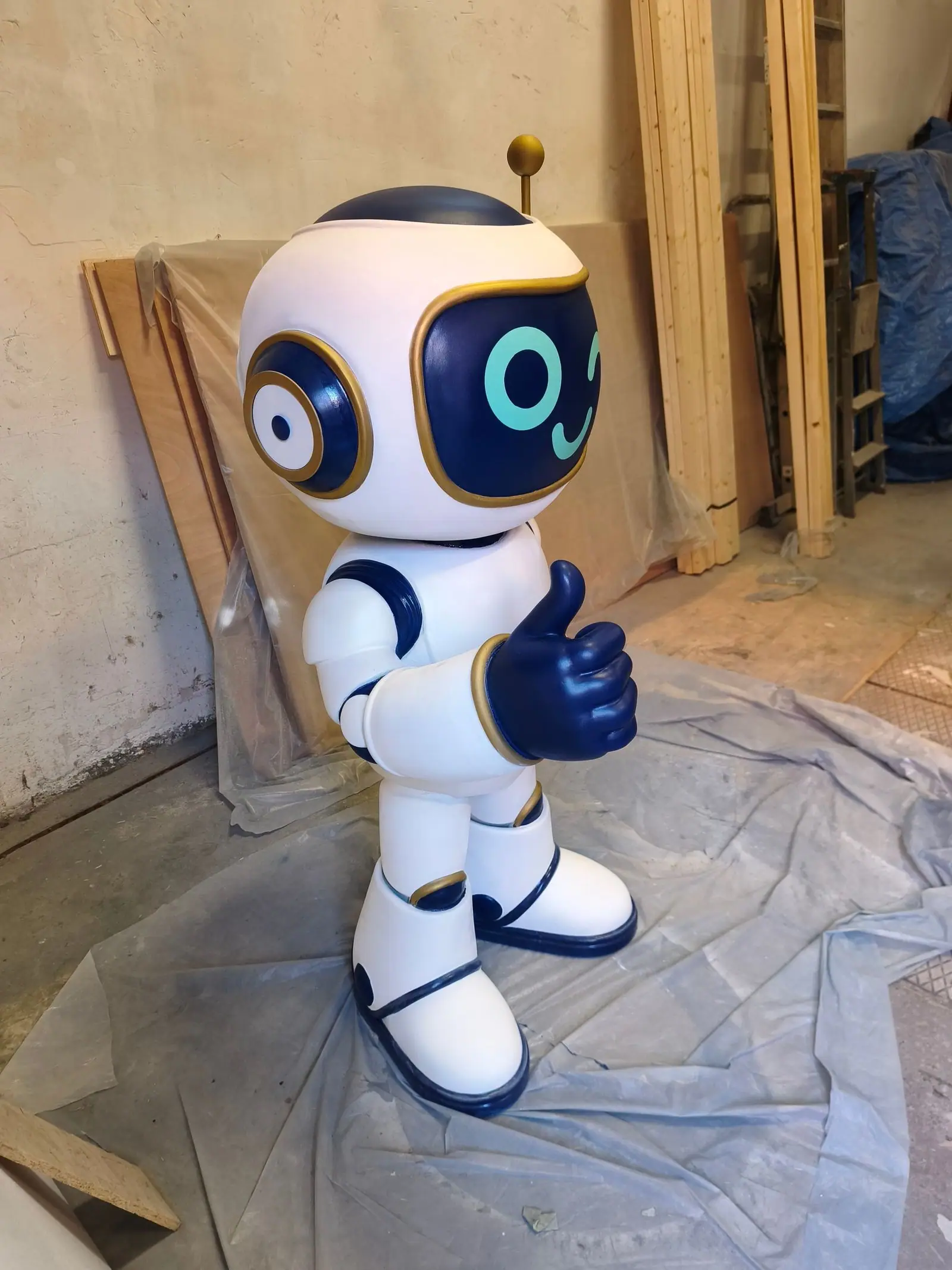 El robot terminado, de tres cuartos, en blanco brillante con detalles en azul y el pulgar arriba