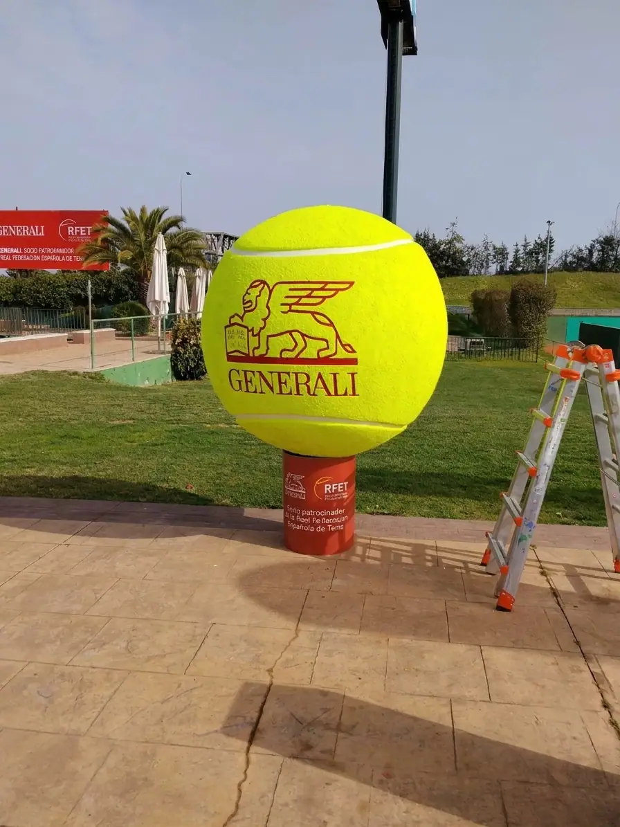 Pelota de tenis gigante con el logotipo de Generali sobre una peana roja al aire libre