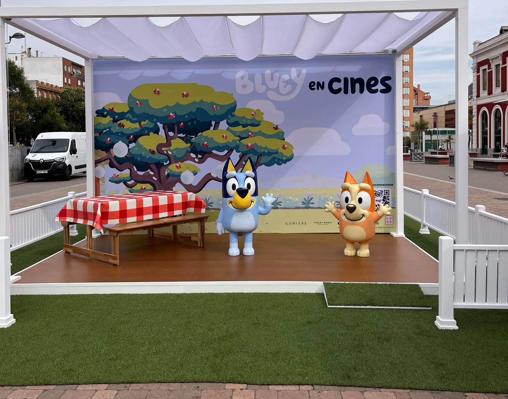 Decorado de Bluey en cines en una plaza, con tarima, pérgola y las figuras de Bluey y Bingo