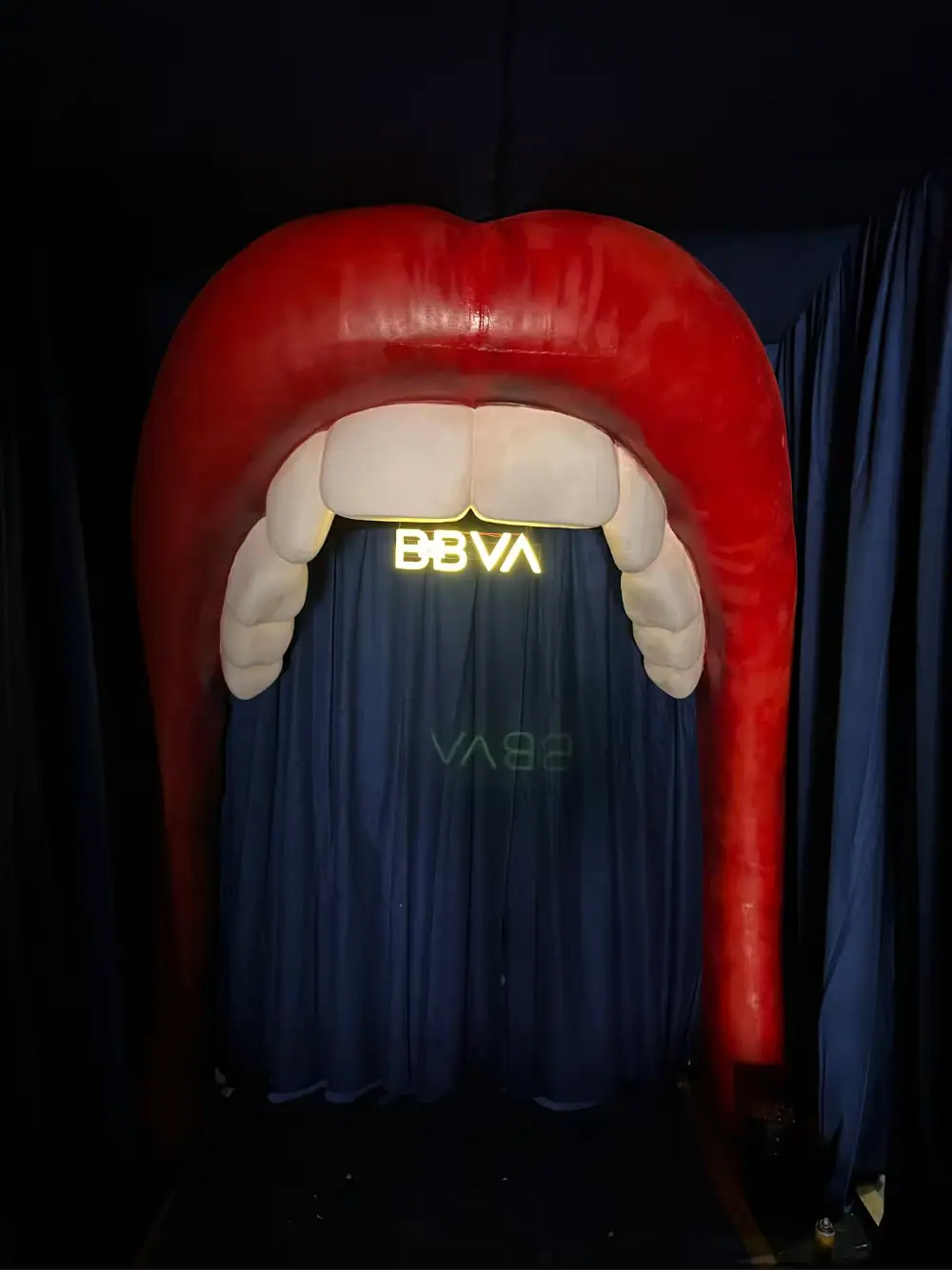 Photocall con forma de boca gigante con labios rojos, dientes y el logotipo de BBVA dentro