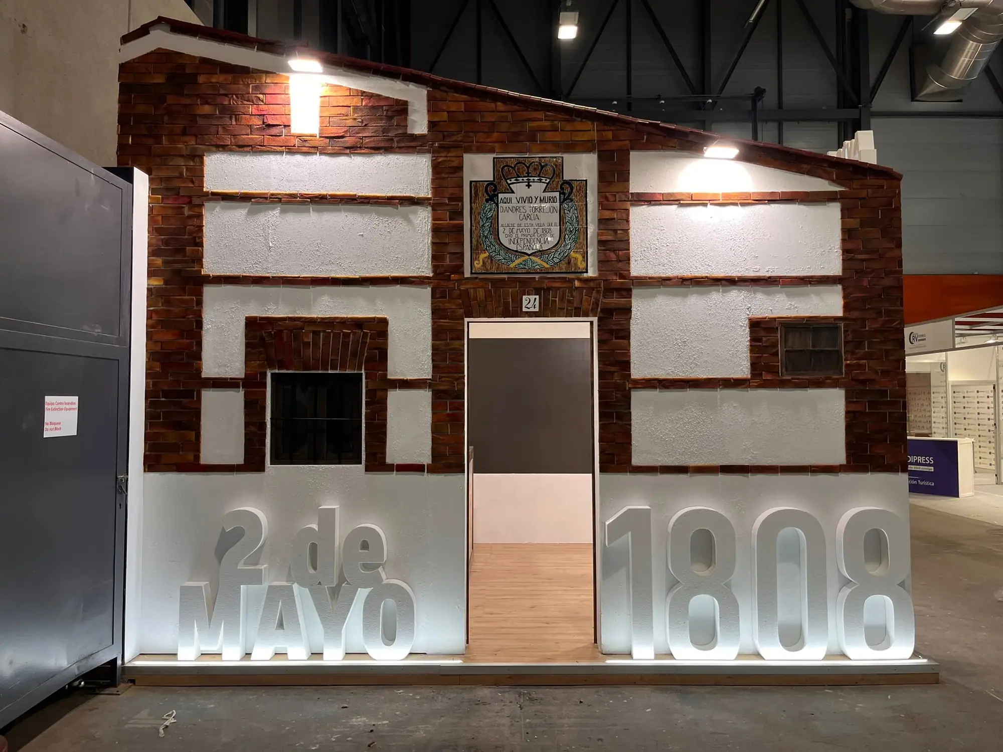 Fachada de una casa antigua de ladrillo y vigas de madera con las letras 2 de mayo 1808