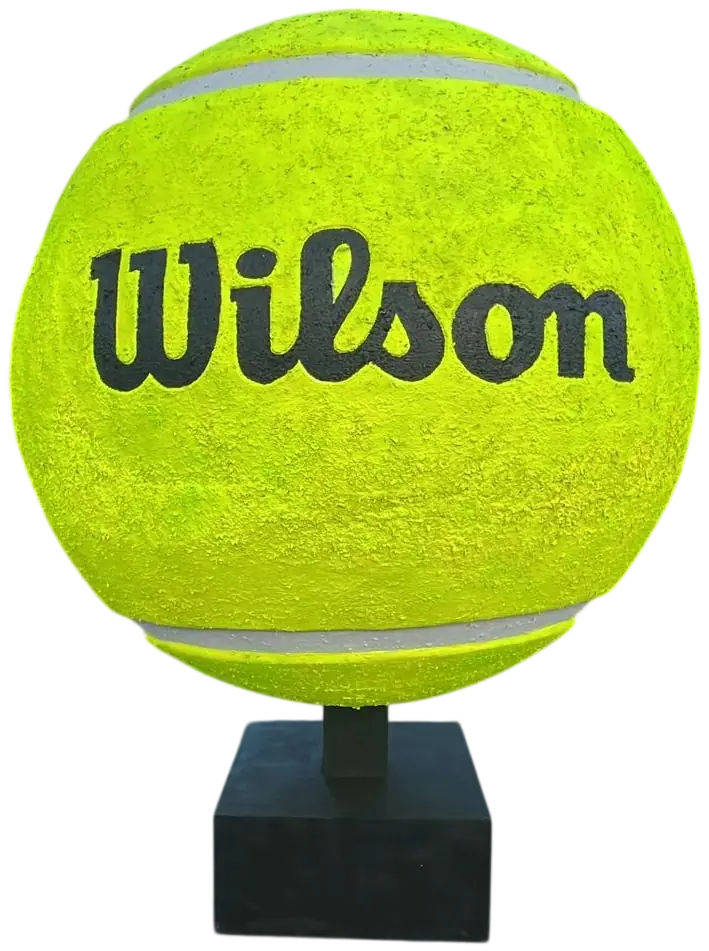 Pelota de tenis gigante de fibra de vidrio con el logotipo de Wilson, sobre su peana