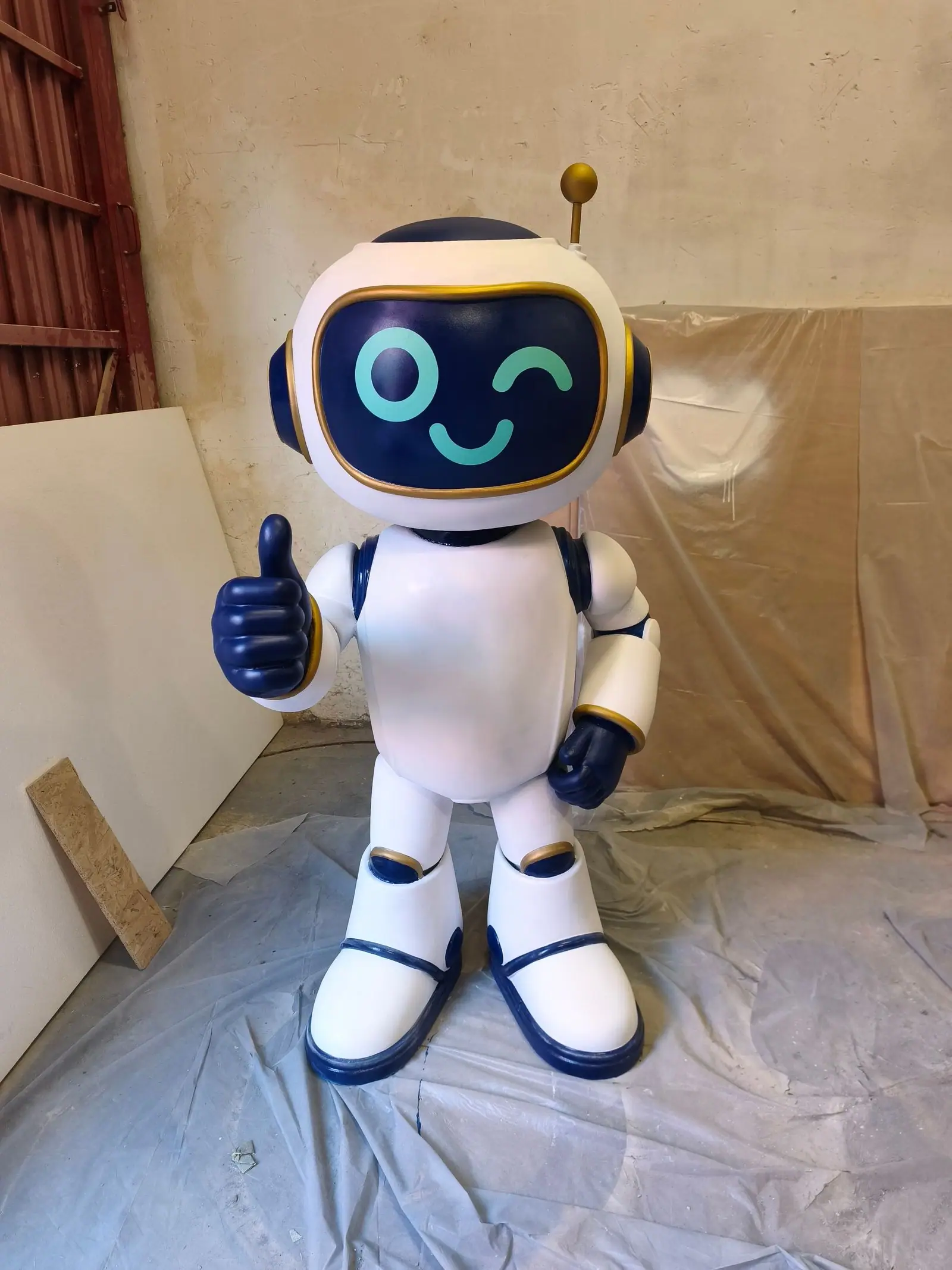 El robot terminado, de frente, guiñando un ojo en su cara de pantalla