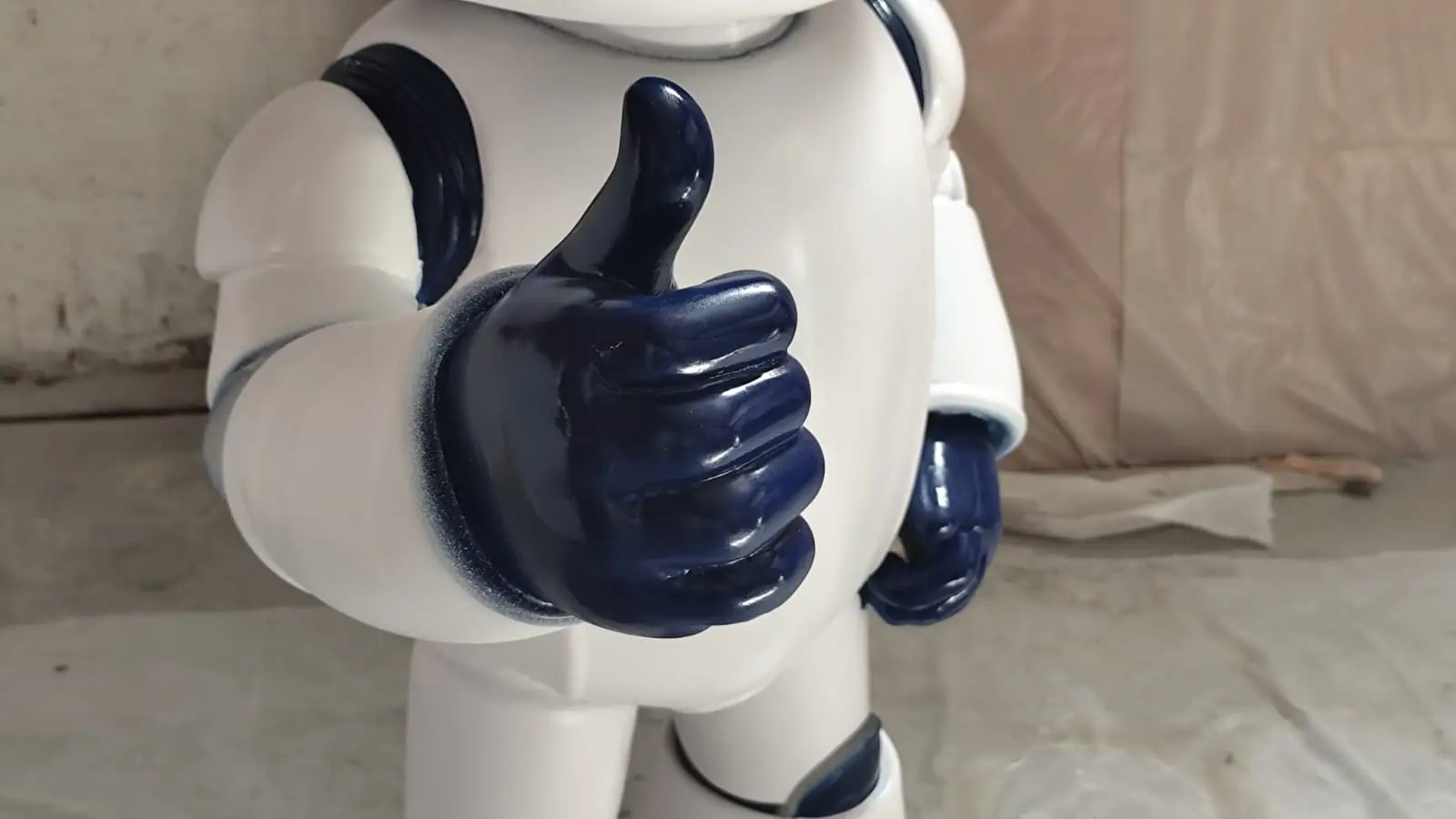 Detalle de la mano azul del robot con el pulgar arriba