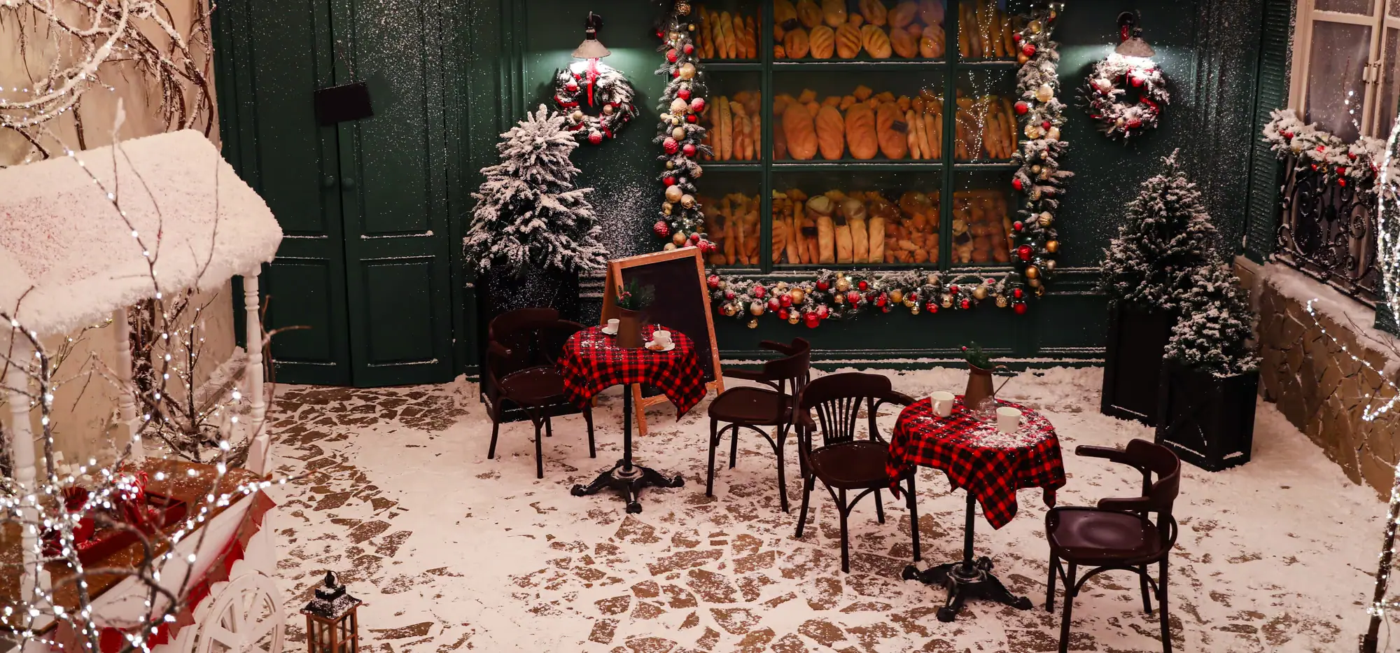 Decorado de una panadería con su fachada, un toldo y una terraza nevada, adornado para Navidad