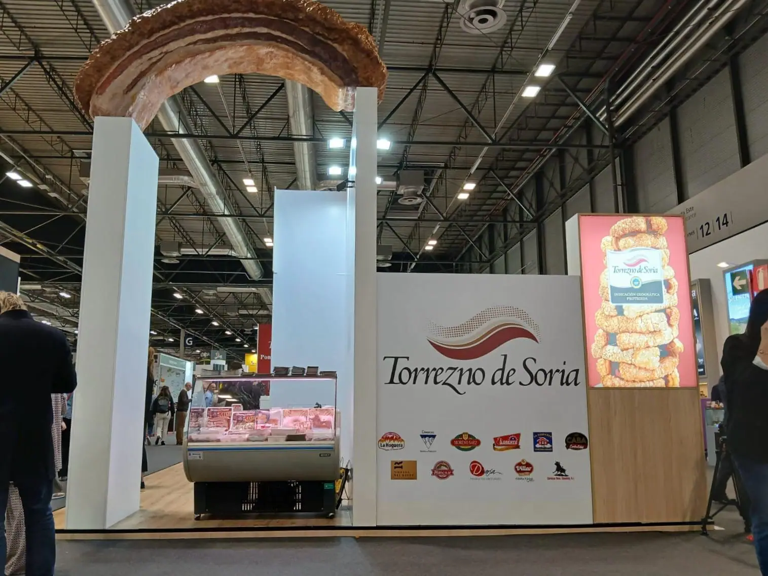 El stand de Torrezno de Soria en IFEMA con el torrezno gigante en lo alto de la columna