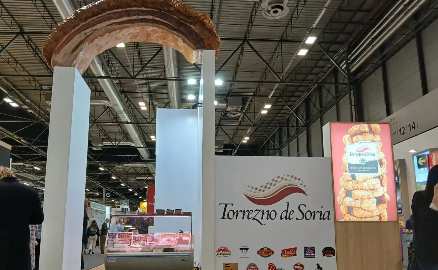 Torrezno de Soria gigante de poliespán sobre el stand de Torrezno de Soria en una feria