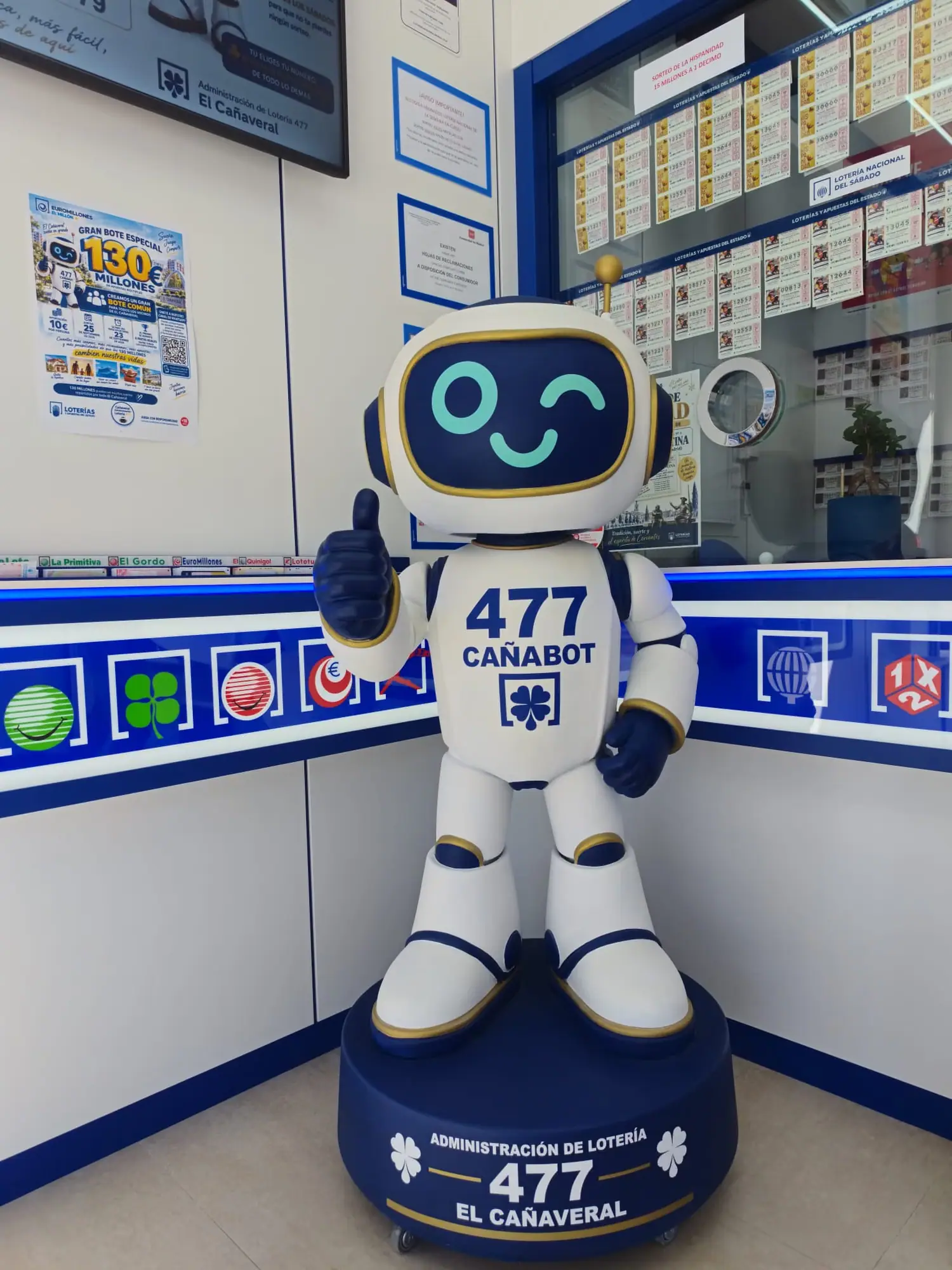 Cañabot, la mascota de la administración de lotería 477, sobre su peana dentro de la tienda